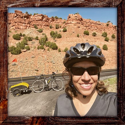 Photo, Day 24 of the TransAmerica Bicycle Trail, Mandy in front of red rock formations.