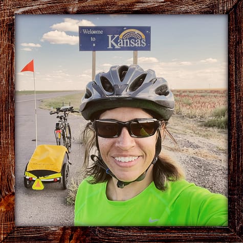 Photo, Day 36 of the TransAmerica Bicycle Trail, Mandy with her bicycle in front of the sign "Welcome to Kansa"