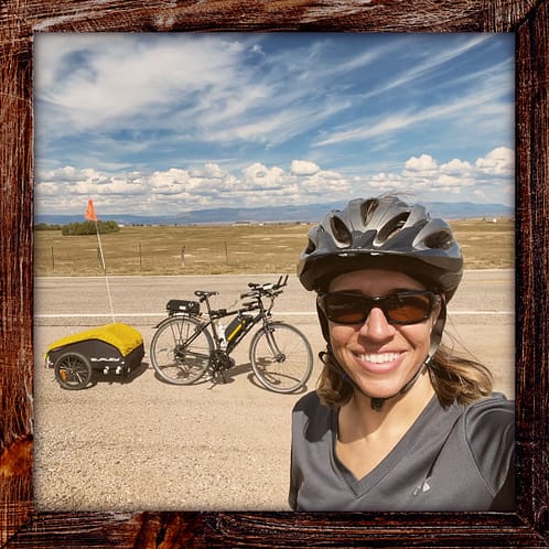 Photo, Day 33 of the TransAmerica Bicycle Trail, Mandy with her bicycle with Pikes Peak in the background