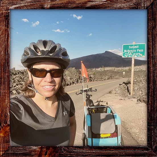 Photo, Day 05 of the TransAmerica Bicycle Trail, Mandy and bicycle in front of McKenzie Pass Oregon elevation sign (5,325 feet)