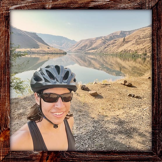 Photo, Day 11 of the TransAmerica Bicycle Trail, Mandy in front of the Snake River and its mountains on the Oregon-Idaho border