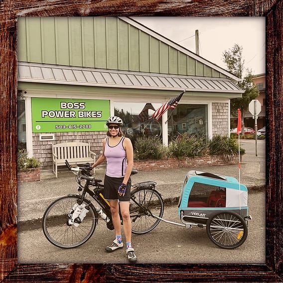 Photo, Day 01 of the TransAmerica Bicycle Trail, Mandy and her bicycle in front of Boss Power Bikes in Tillamook Oregon